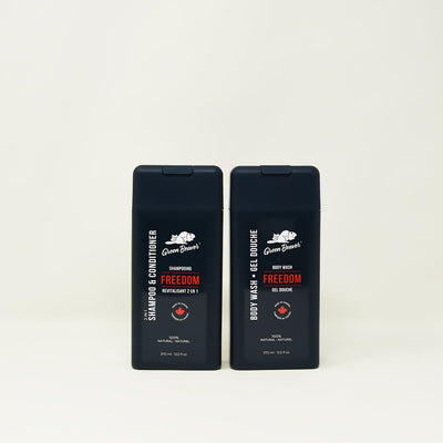 Two dark green bottles of Freedom scent products for the Men's line from Green Beaver sit on a beige background.