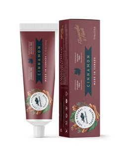 A tube of cinnamon natural toothpaste from Green Beaver is placed vertically next to its box on a white background.