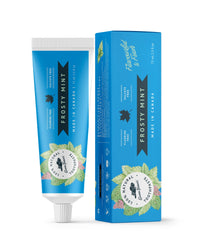 A tube of frosty mint natural toothpaste from Green Beaver is placed vertically next to its box on a white background.