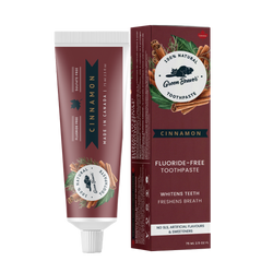 A tube of cinnamon natural toothpaste from Green Beaver is placed vertically next to its box on a white background.