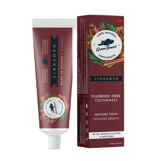 A tube of cinnamon natural toothpaste from Green Beaver is placed vertically next to its box on a white background.