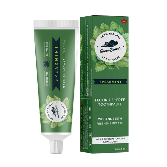 A tube of spearmint natural toothpaste from Green Beaver is placed vertically next to its box on a white background.