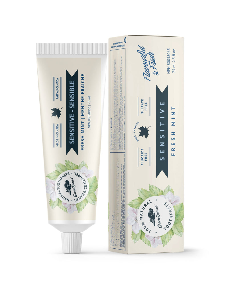A tube of mint sensitive teeth natural toothpaste from Green Beaver is placed vertically next to its box on a white background.